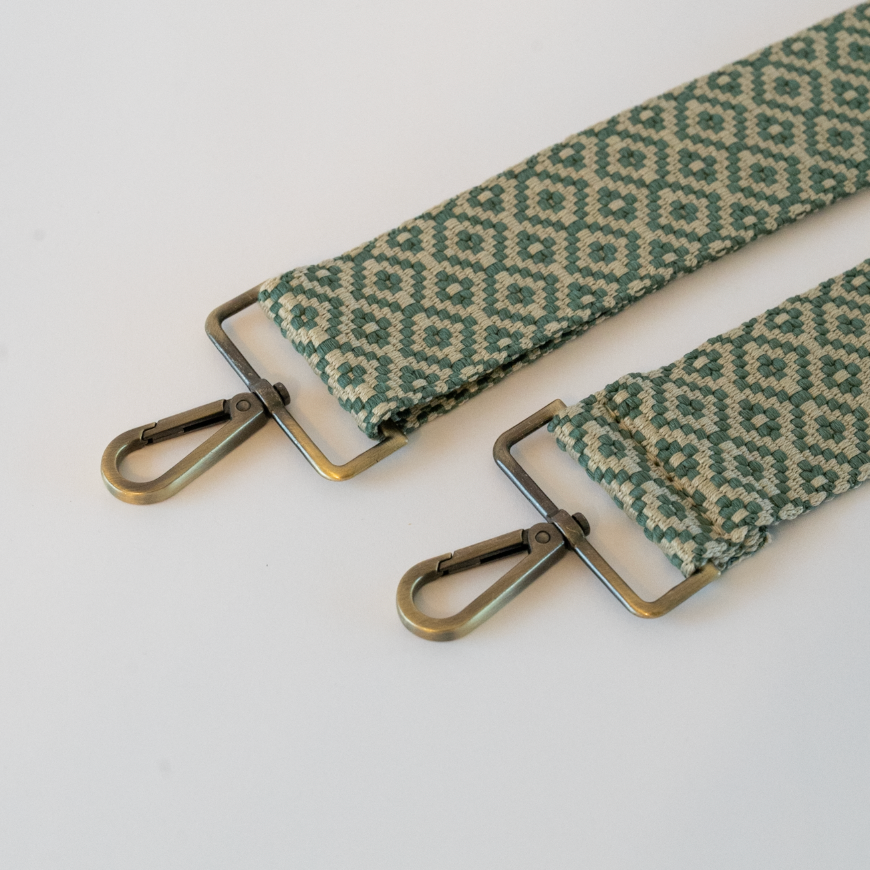 Fabric strap with green geometric pattern and antique brass hardware