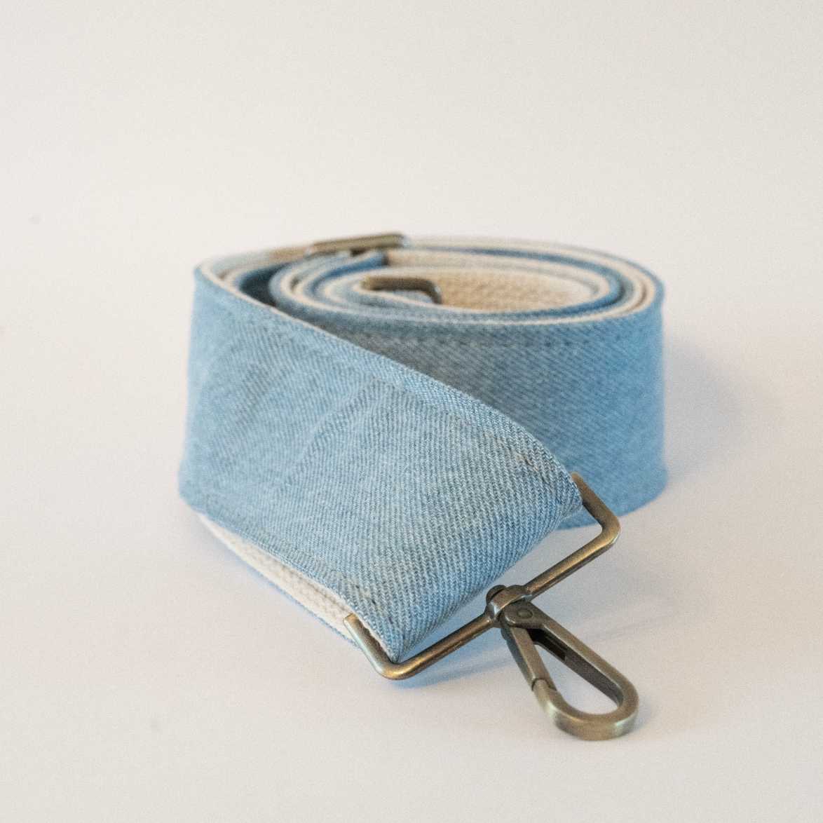 Light blue strap with metal buckle on a white background